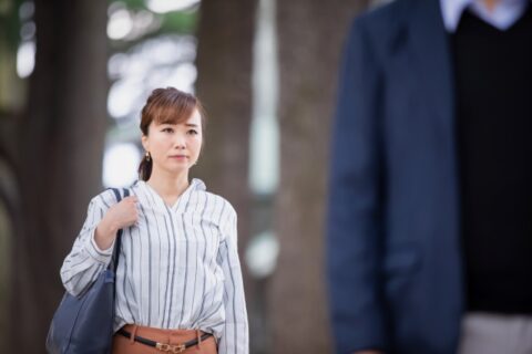 男性の後ろ姿を見つめる女性