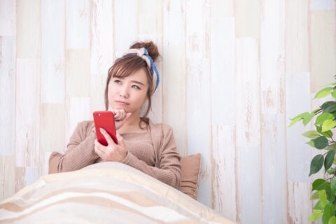 スマホを持って考える女性